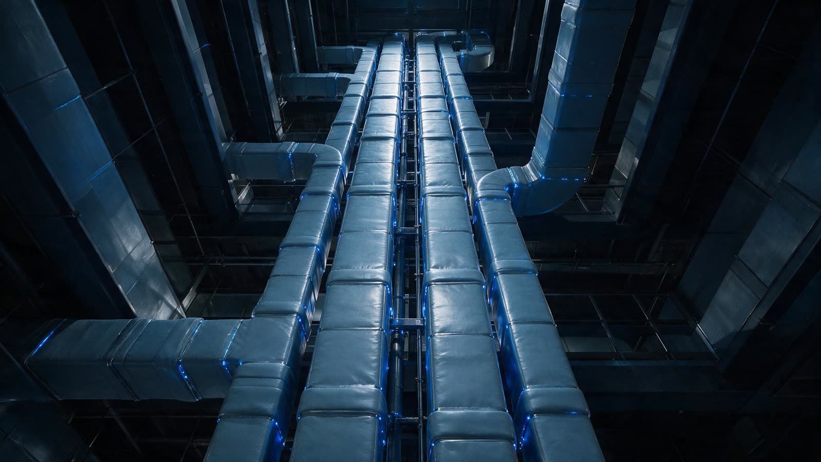 Parallel insulated ventilation ducts rising through a building services riser